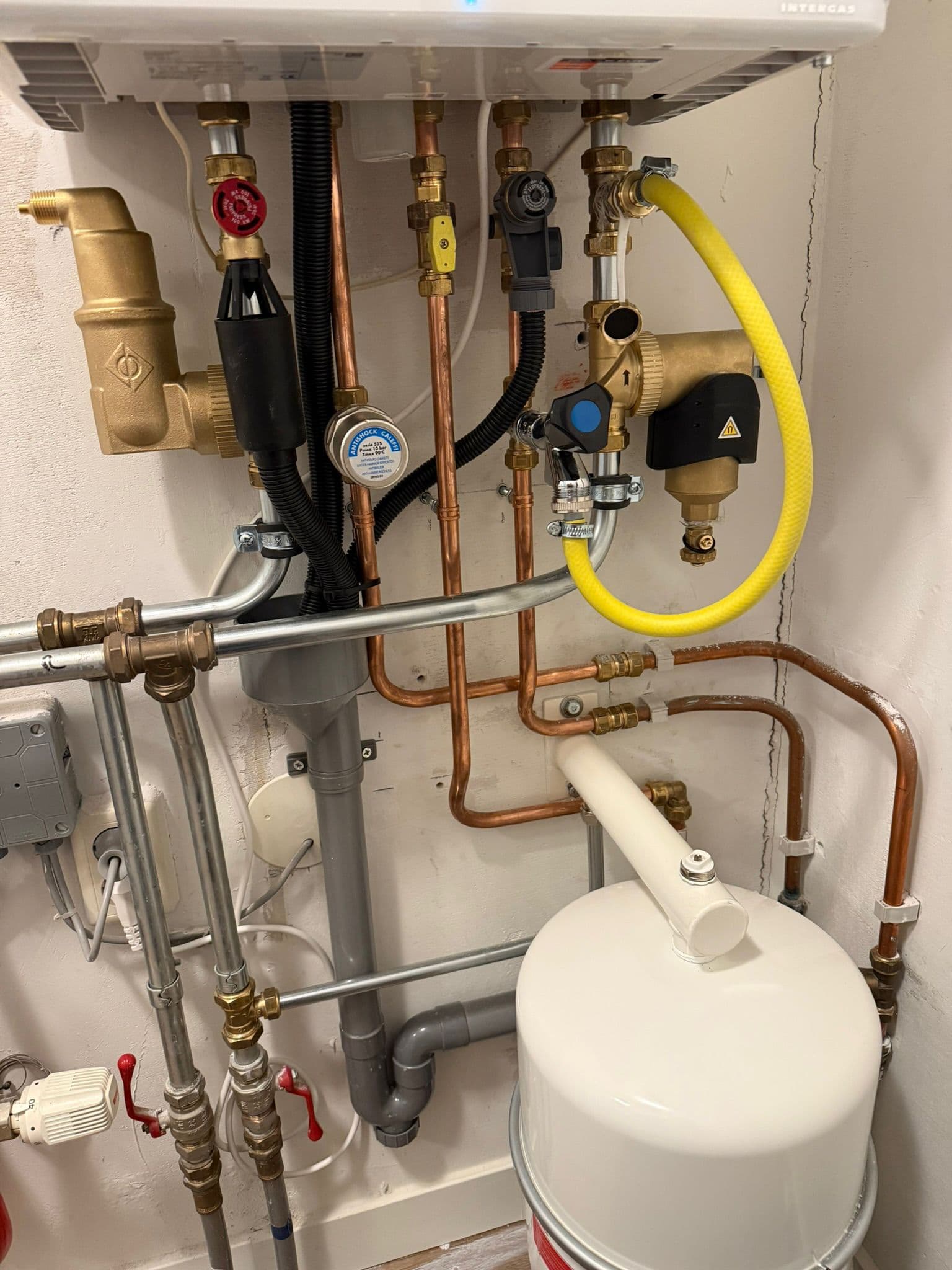 Intergas cv-ketel installatie met koperen leidingen, gele gasslang en expansievat