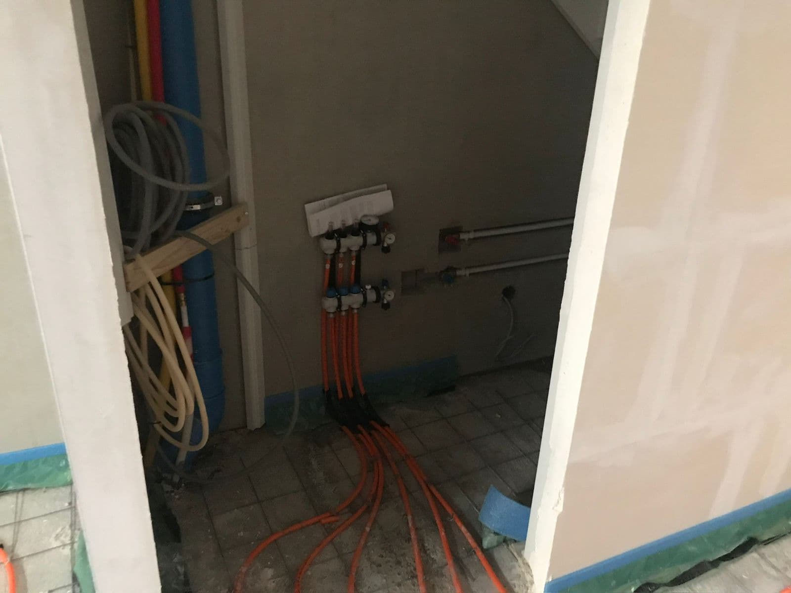 Verdeelunit vloerverwarming met meerdere oranje aansluitgroepen en afsluiters